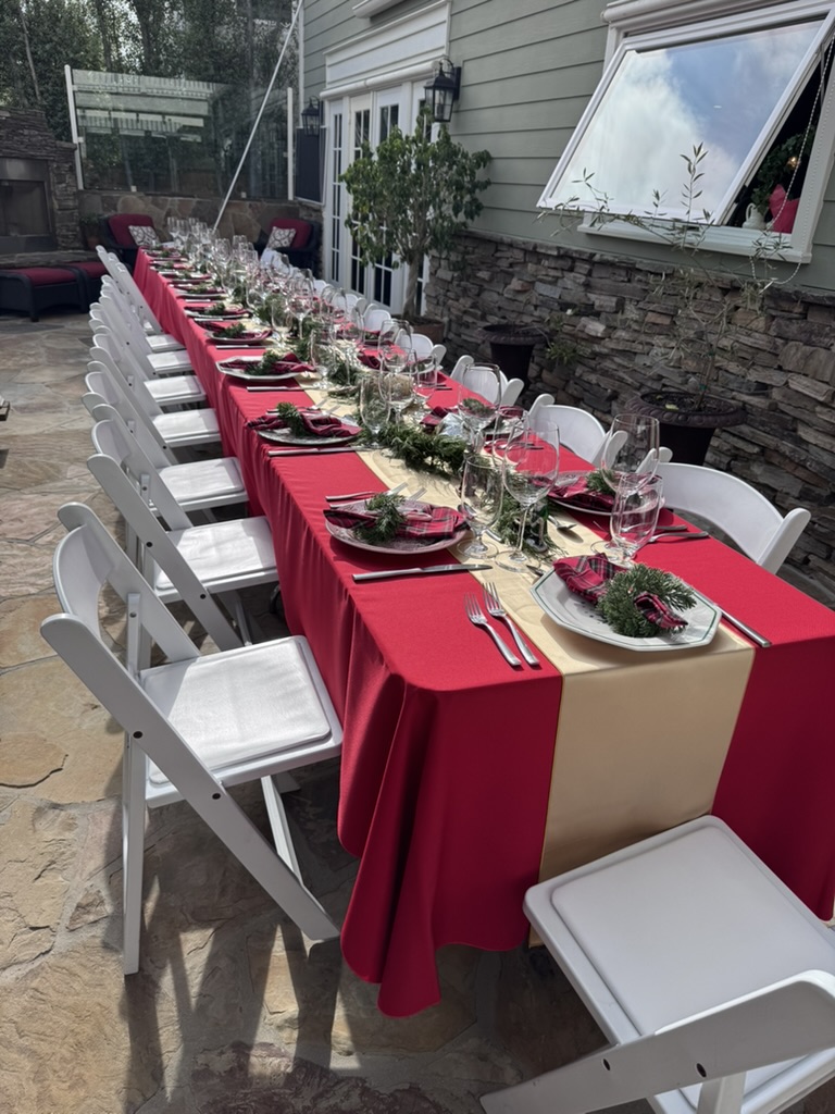 A long Christmas dinner table dressed in red and gold