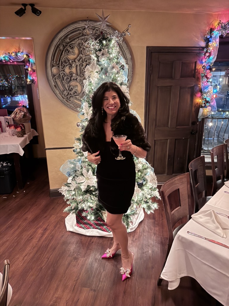 Kandi celebrating beside a decorated Christmas tree